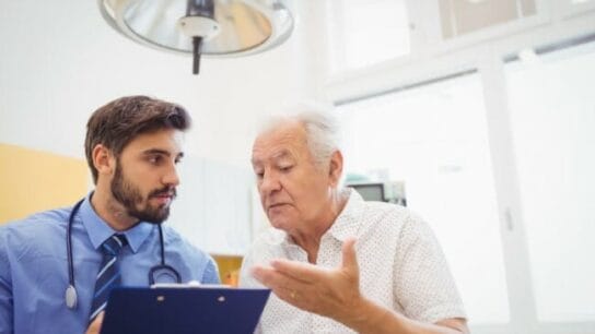 An elderly patient speaks with a doctor.